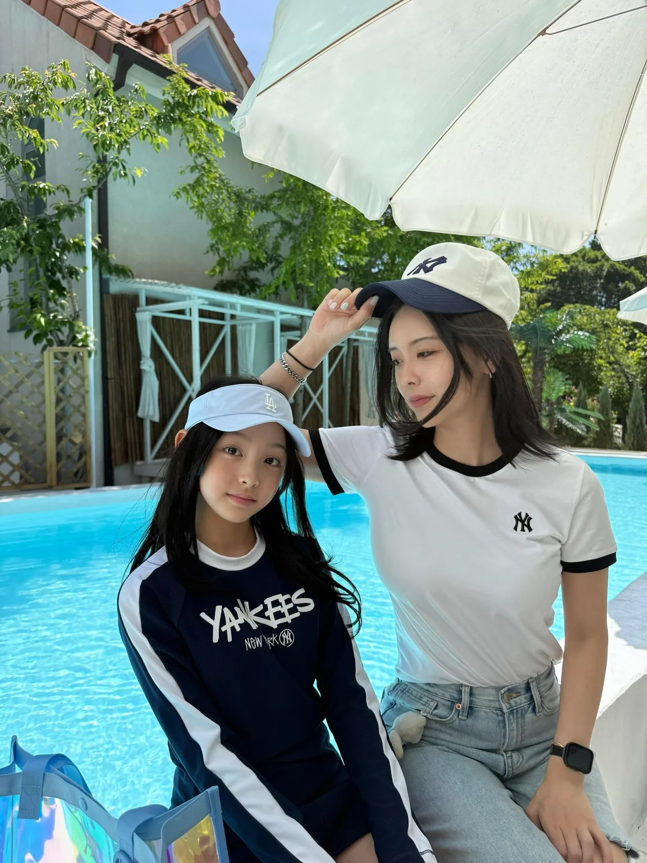 수영장 앞에서 파라솔 아래 포즈를 취한 모녀 룩 / 사진=MLB키즈