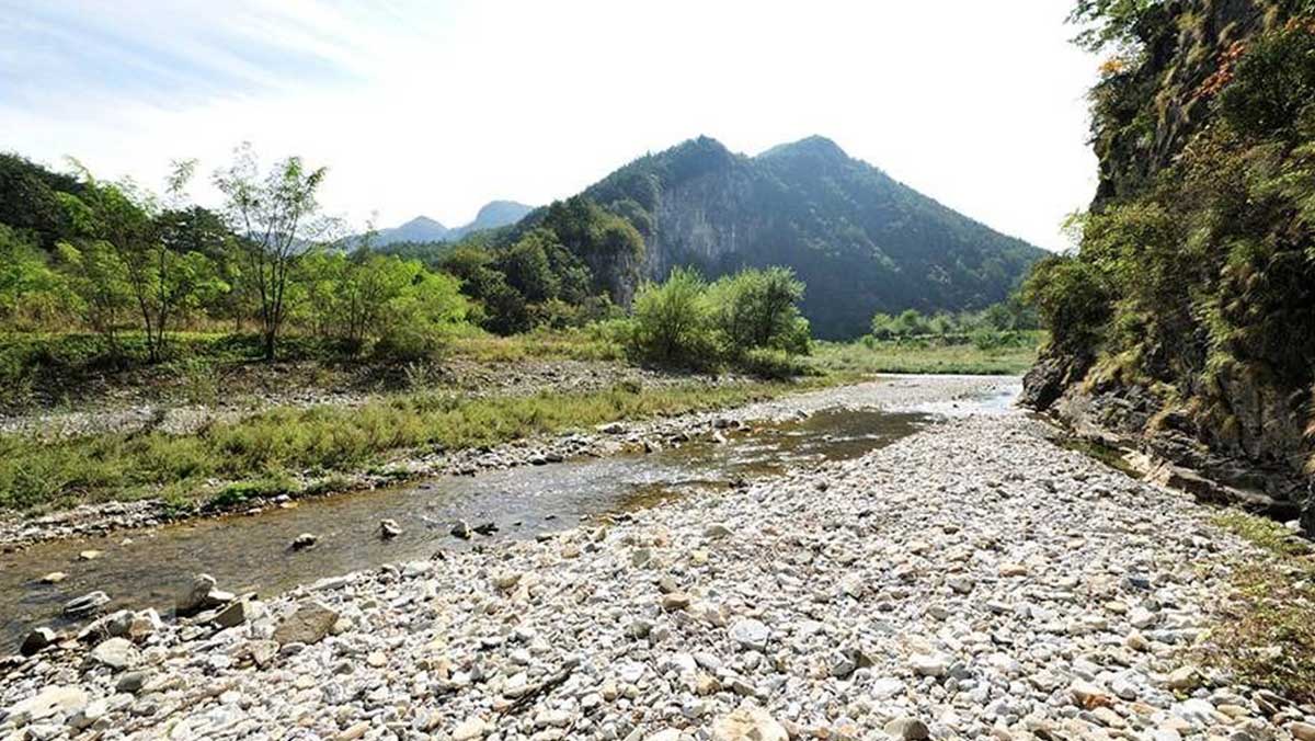 정선 덕산기 계곡 하류에 자갈밭과 물길이 이어지고, 뒤로 산 능선이 펼쳐져 있다. / 한국관광공사