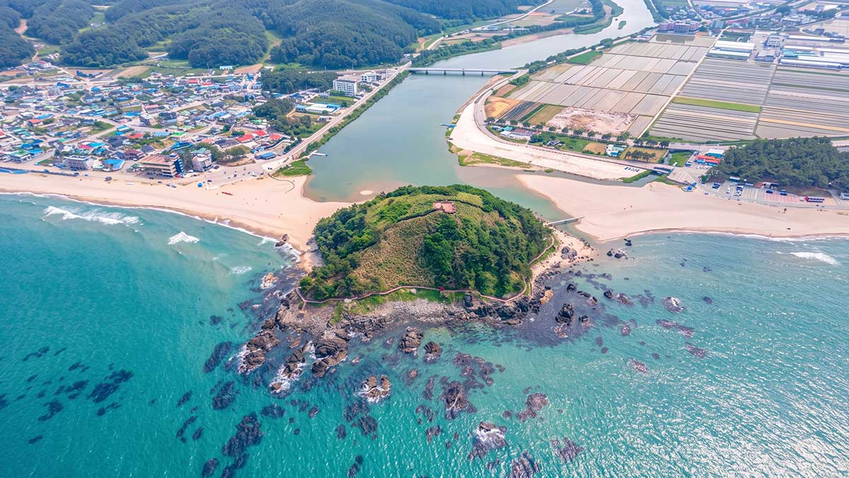 덕봉산을 중심으로 왼쪽의 맹방해수욕장과 오른쪽의 덕산해수욕장이 시원하게 펼쳐진 전경. / 한국관광공사, ai