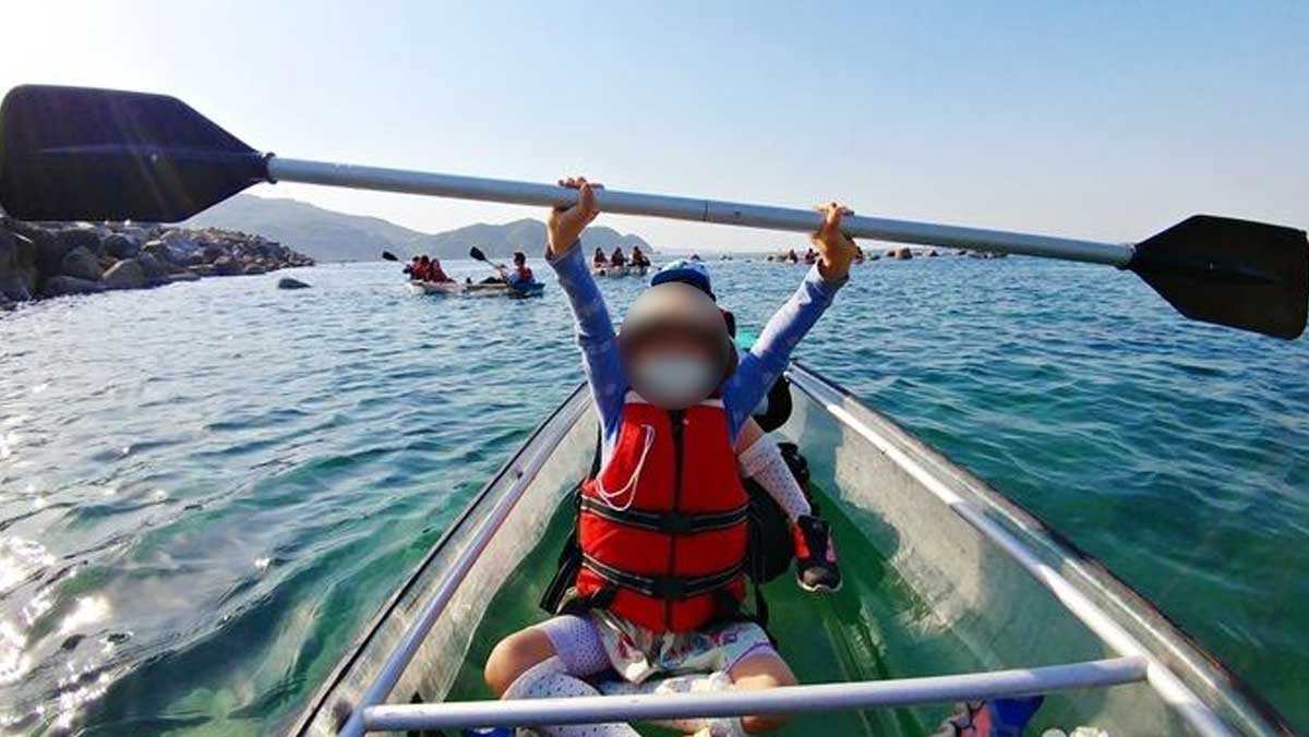 투명카누를 탄 어린이가 패들을 들어 올리며 맑은 바다 위에서 즐거운 시간을 보내고 있다. / 한국관광공사
