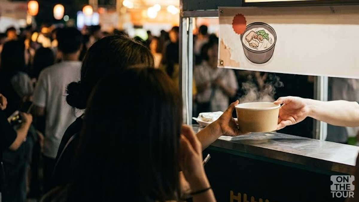 부스에서 방문객이 따끈한 돼지국밥 라면을 건네받고 있다.(AI 생성) . / 온더투어
