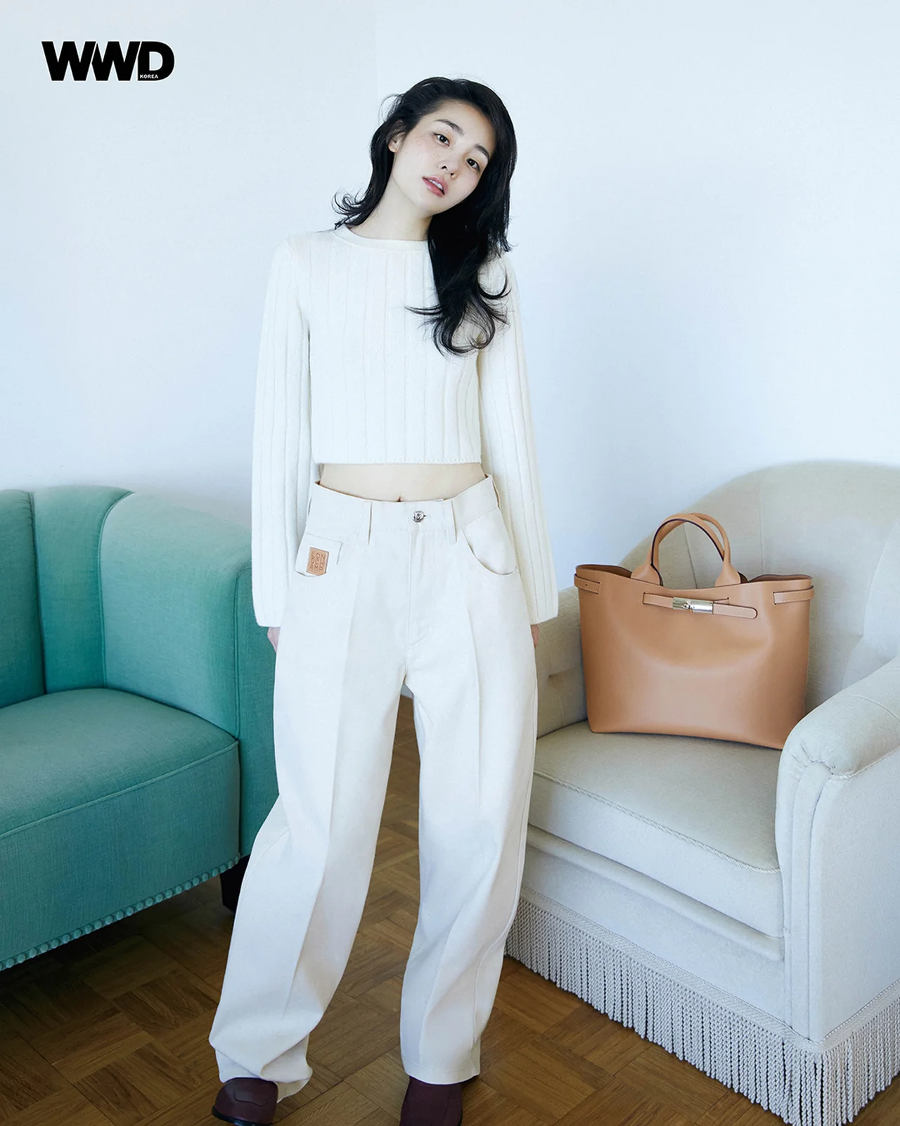 김민하가 크롭 기장의 아이보리색 니트와 와이드 팬츠를 입고 베이지색 토트백과 함께 포즈를 취하고 있다. / 사진=WWD KOREA