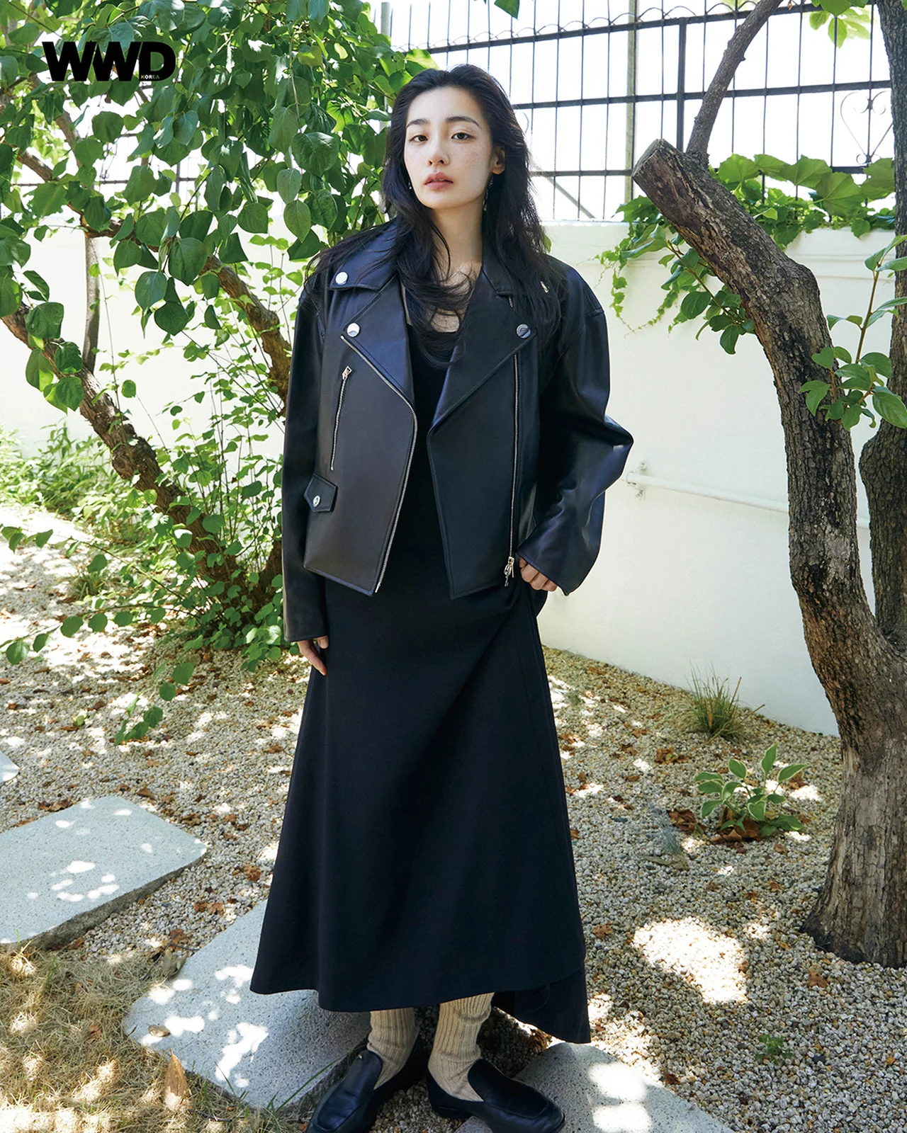 검은색 가죽 재킷과 롱 원피스를 입고 야외 정원에서 시크한 매력을 뽐내는 김민하. / 사진=WWD KOREA