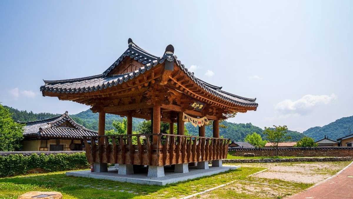 푸른 하늘과 산을 배경으로 기와지붕을 얹은 커다란 목조 정자가 탁 트인 공간에 세워져 있다. / 한국관광공사