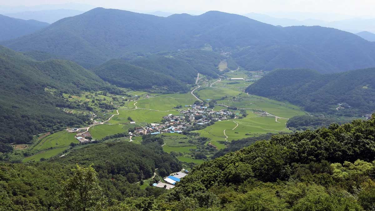 명상바위 아래로는 굽이진 산맥에 포근하게 안긴 학동마을과 논밭의 전경이 시원하게 펼쳐진다. / 경주시