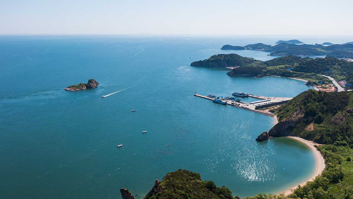 푸른 바다와 초록빛 산세가 어우러진 대련 해안 전경. / oceana1214-shutterstock