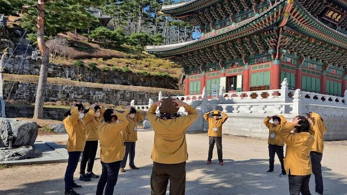 관람객들이 노란 단체복을 맞춰 입고 전문 지도사의 동작에 맞춰 체조를 따라 하고 있다. / 산청 동의보감촌