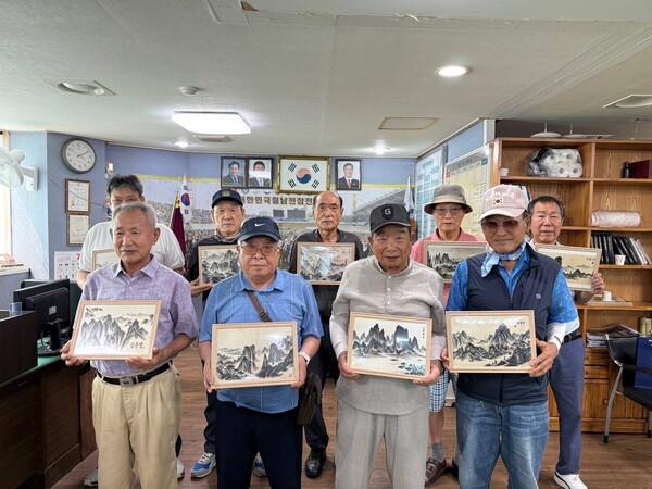 지난 23일 신천지자원봉사단 부산서부지부가 월남전참전자회 사하구지회를 방문하여 '맥박으로 그린 AI수묵화'를 전달한 가운데 참전용사들과 기념촬영을 하고 있다. (사진제공=신천지자원봉사단 부산서부지부)