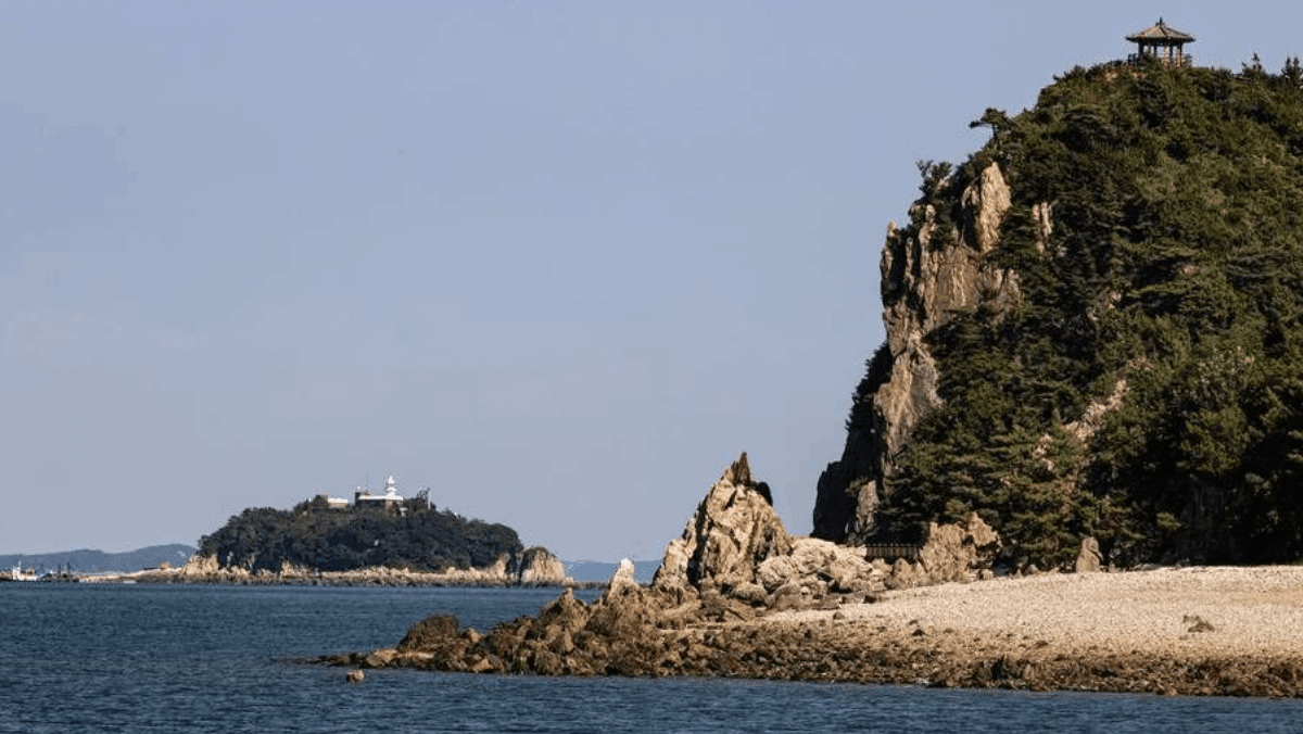 촛대바위와 오른쪽 암벽 정자, 그리고 저 멀리 보이는 등대 섬. / 한국관광콘텐츠랩
