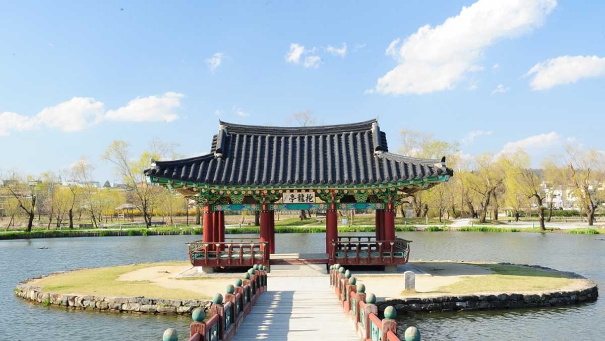 연못을 가로지르는 다리 너머로 보이는 포룡정. / 충남관광