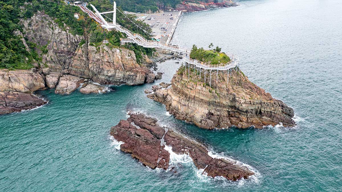 붉은 기암절벽과 동섬을 어우르는 송도 용궁 구름다리 전체 전경. / ⓒ한국관광콘텐츠랩-이범수