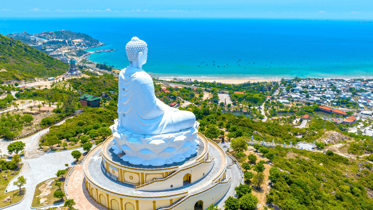 푸른 바다와 해안 마을을 굽어보는 언덕 위 거대 좌불상 전경. / Huy Thoai-shutterstock