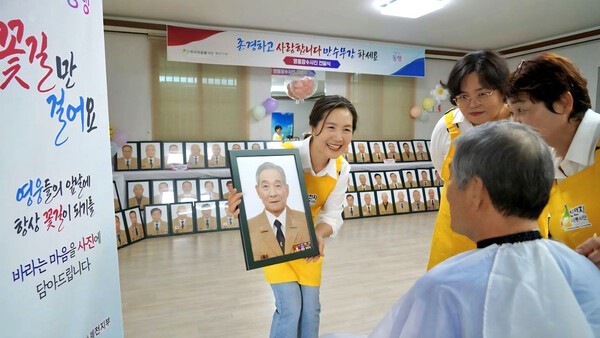 지난 3월 신천지자원봉사단 제천지부 봉사자들이 보훈 어르신에게 장수 사진 촬영 후 완성된 사진을 보여주며 이야기를 나누고 있다. (사진제공=신천지자원봉사단)