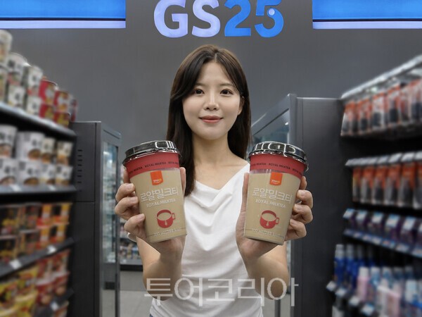 GS25에서 모델이 유어스로얄밀크티를 들고 있다