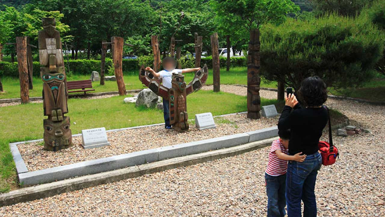 이색적인 장승 조형물 앞에서 기념 사진을 촬영하며 즐거운 시간을 보내는 관람객들. / 청양군