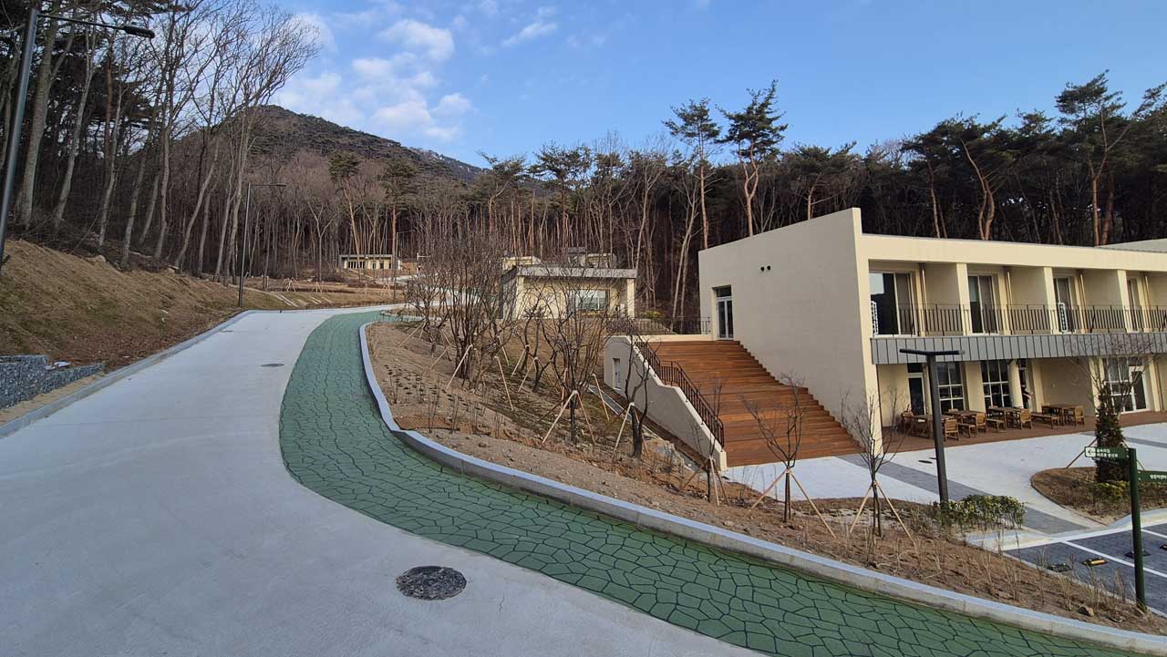 산책로와 깔끔하게 어우러진 현대적인 산림문화휴양관 외관. / 숲나들e