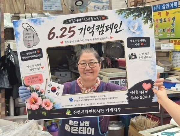 신천지자원봉사단 거제지부의 '6·25 기억 캠페인'에 동참해 기념사진을 촬영 중인 옥포국제시장 상인의 모습. (사진제공=신천지자원봉사단 거제지부)