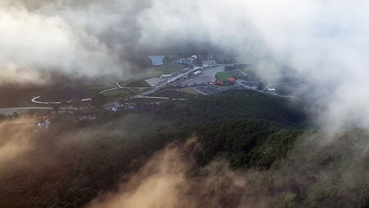 산자락과 아래 주차장 위로 몽환적인 안개가 자욱하게 깔린 구봉산의 운치 있는 풍경. / 진안군