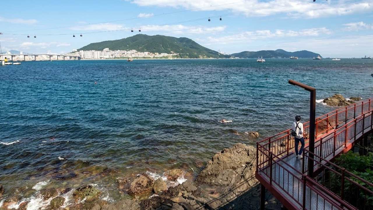탁 트인 송도 바다와 하늘 위 케이블카를 조망하며 걷는 해안 산책로. / 비짓부산
