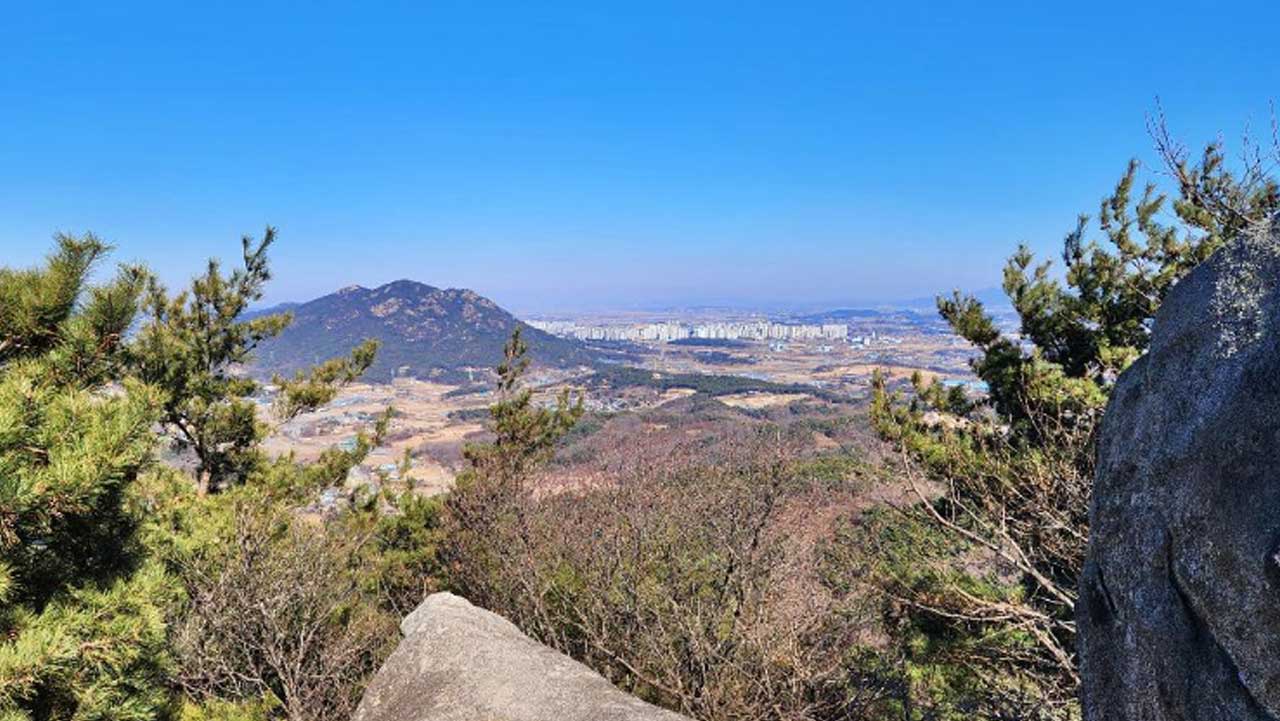 기암괴석과 소나무가 어우러진 백월산 정상에서 시야가 탁 트인 조망 풍경. / 충남시