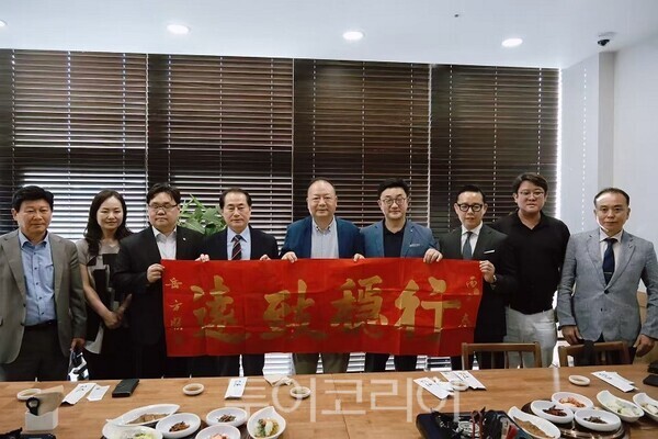 한중문화경제교류협회 박태성 회장(좌)이 사천성 민영문화기업협회 웨잔 회장에게 문화 기념품을 전달하는 모습