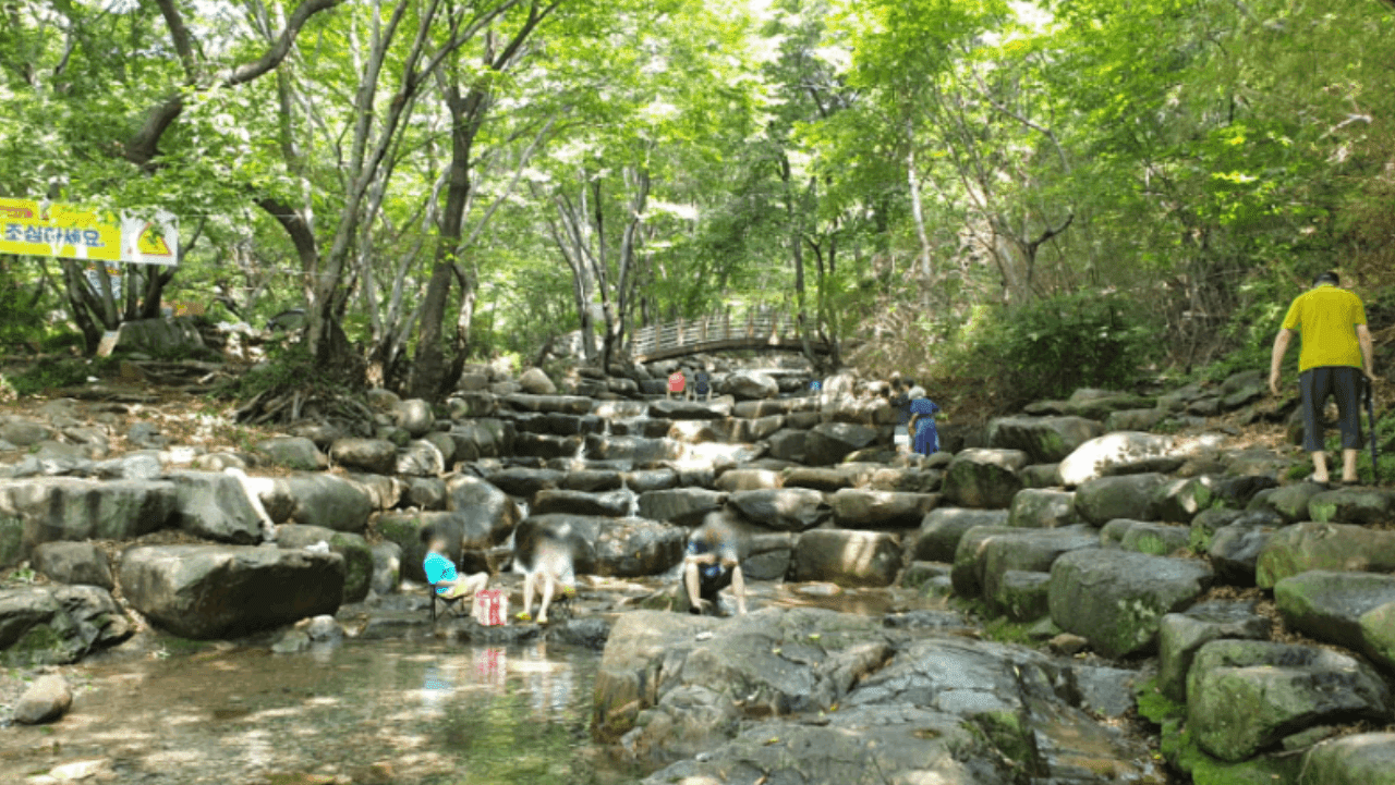 바위 그늘 아래에서 쉬어가는 피서객들 모습. / 창원시