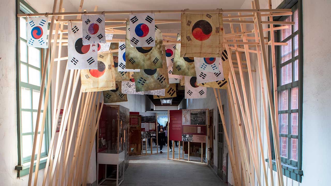 서대문형무소역사관 내부 전시관 복도 천장에 태극기들이 걸려 있는 모습. / ⓒ한국관광콘텐츠랩-김지호