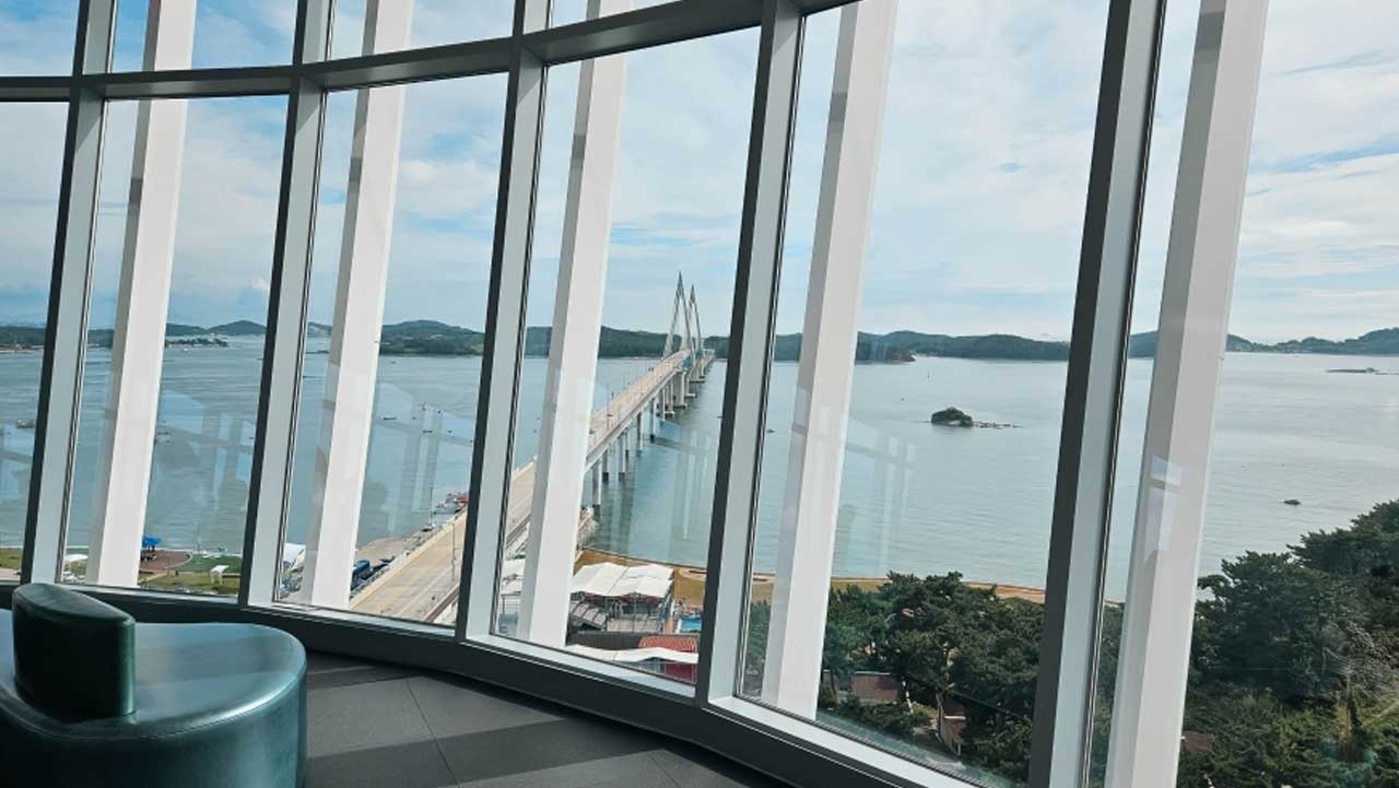 전망층 통유리창 너머로 원산안면대교와 서해 바다, 주변 섬들이 파노라마로 펼쳐지는 조망. / 충남관광