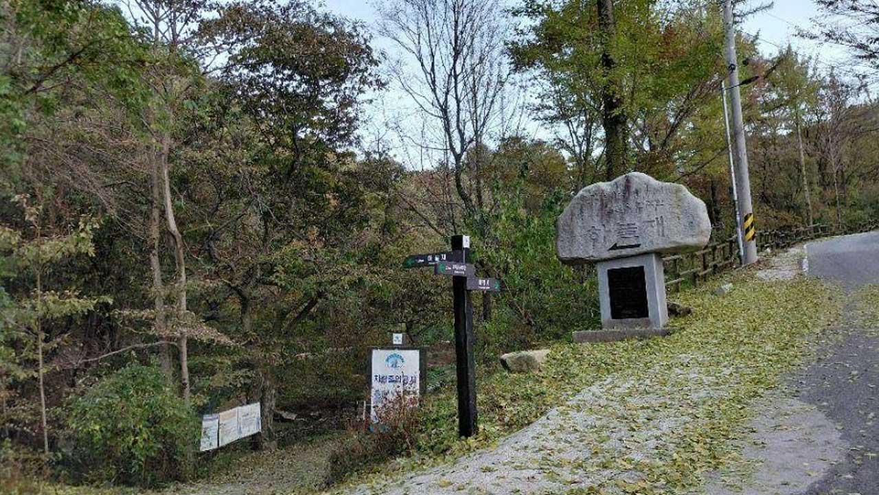 숲길 진입로에 세워진 하늘재 표지석과 갈림길 이정표 풍경. / 한국관광공사