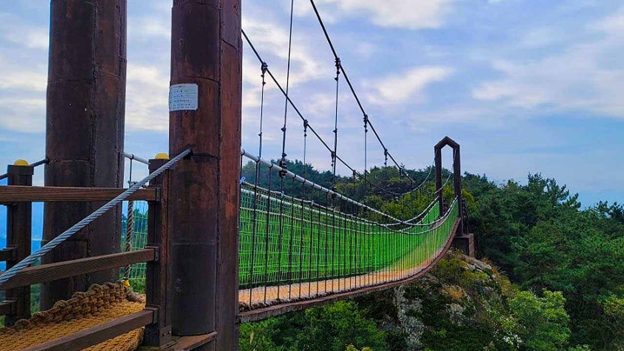 나각산 정상 부근의 두 바위 봉우리를 아슬아슬하게 이어주는 출렁다리 전경. / 상주시