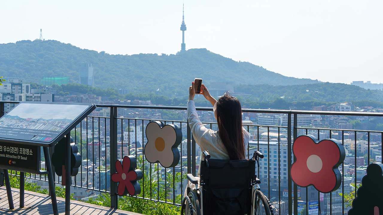 조망 명소에서 멀리 N서울타워와 서울 도심 풍경을 배경으로 기념사진을 남기는 모습. / 내 손안에 서울