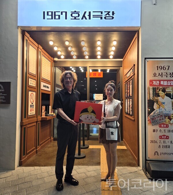 ▲김지광(왼쪽) 공주문화관광재단 대표이사가 지난 14일 1967호서극장에 6000번째로 입장한 한 여성 관람객에게 기념품을 전달하고 있다. /사진-공주문화관광재단