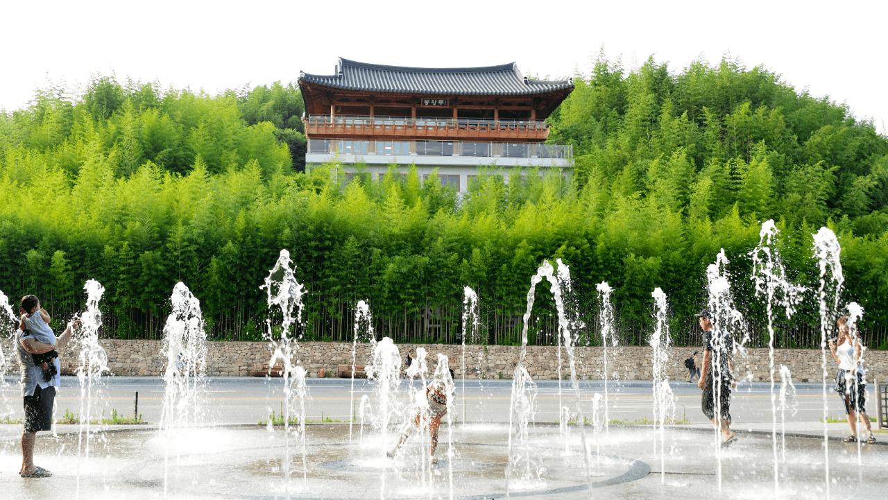 봉황루 전망대와 대나무 숲을 배경으로 시원한 물줄기가 솟아오르는 수변 분수 광장. / 담양군 죽녹원