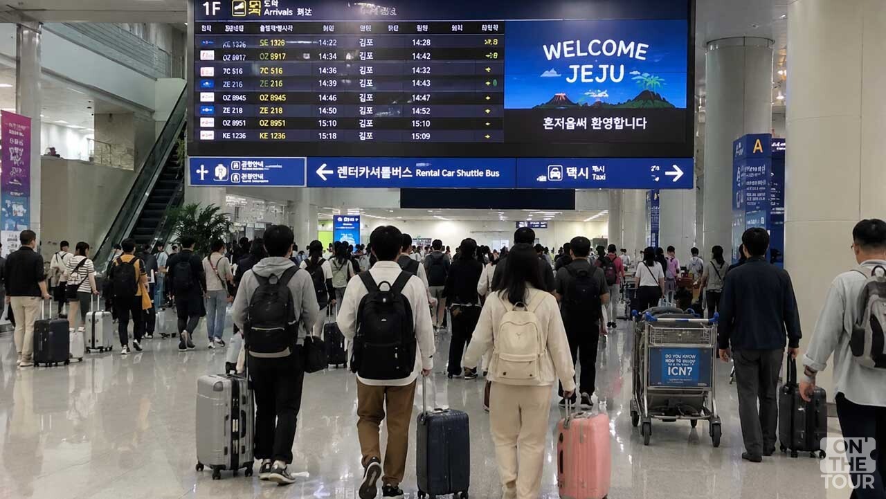 제주국제공항 1층 도착장에서 여행 가방을 끌고 이동하는 방문객들의 모습. / 온더투어