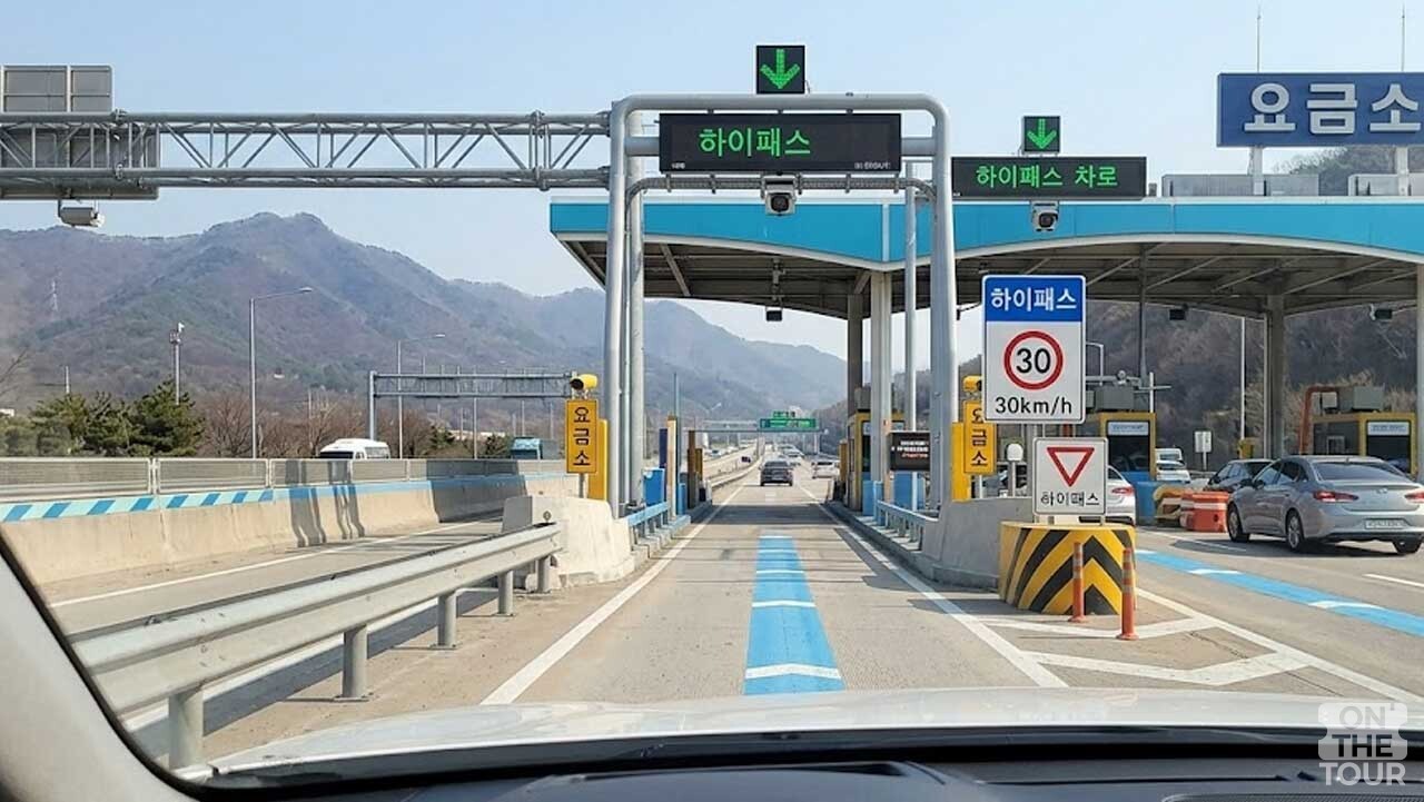 다자녀 통행료 할인 혜택이 적용되는 고속도로 요금소의 하이패스 차로 진입 풍경(AI 생성). / 온더투어