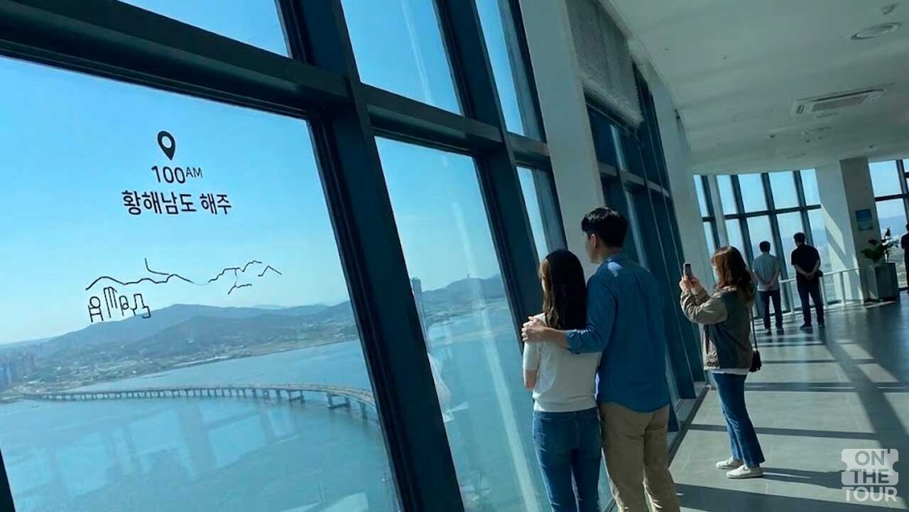 탁 트인 바다 전망과 미디어 안내를 함께 즐길 수 있는 실내 하늘 전망대. (AI 생성) / 온더투어
