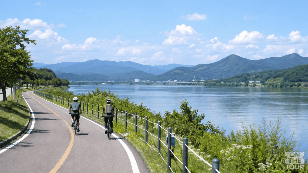 강변 전용 도로를 따라 시원하게 페달을 밟는 가을 자전거 라이딩 모습. (AI 생성) / 온더투어