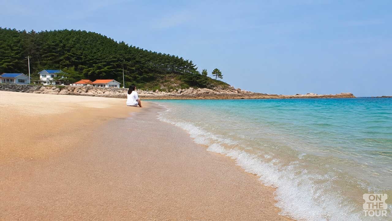 맑은 바다와 넓은 모래사장이 펼쳐진 강원도 고성의 한적한 해변. (AI 생성) / 온더투어