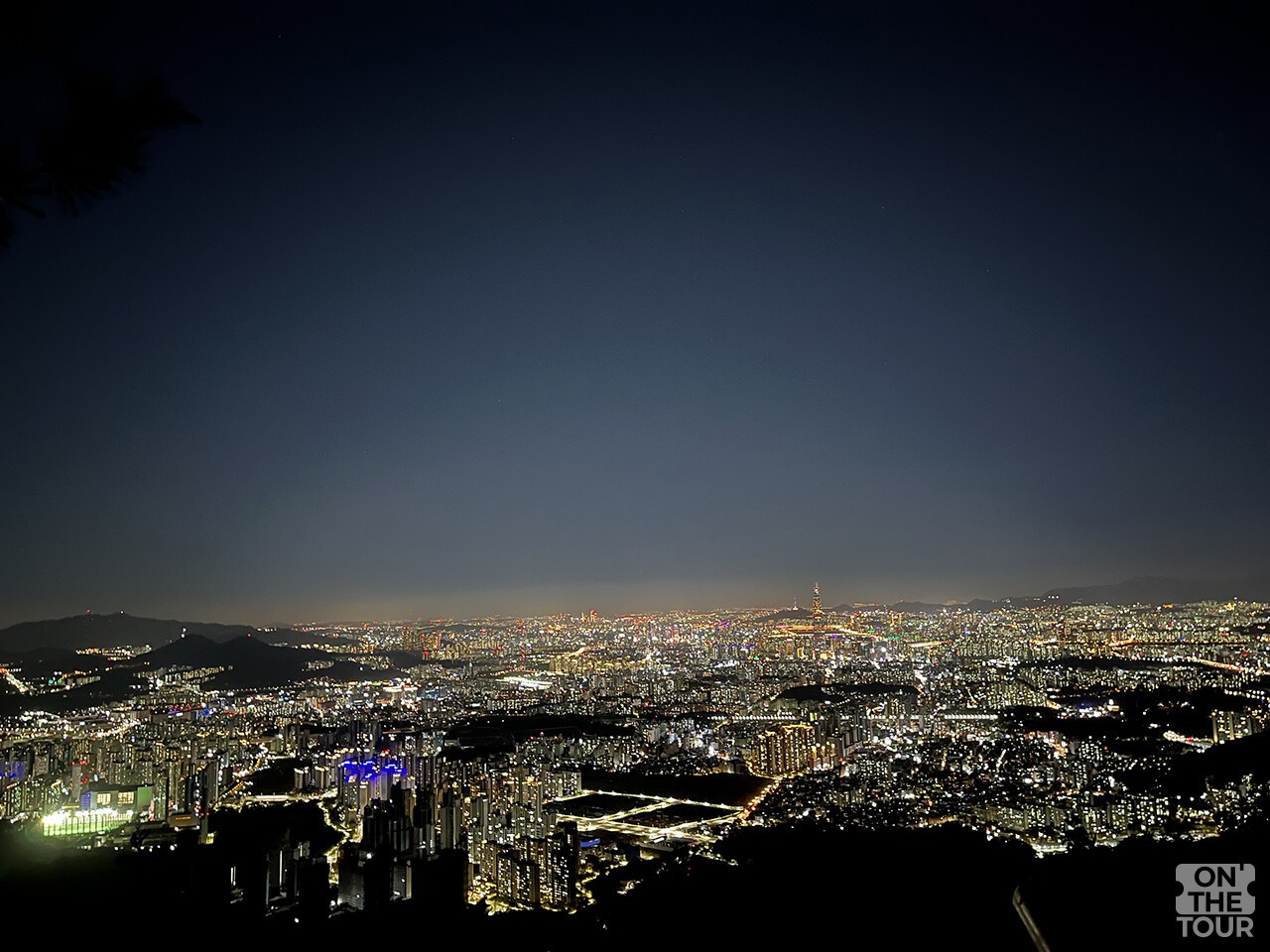 남한산성 서문 전망대에서 바라본 서울 도심 야경. 산 아래로 빌딩과 아파트 불빛이 넓게 펼쳐진다. / 온더투어