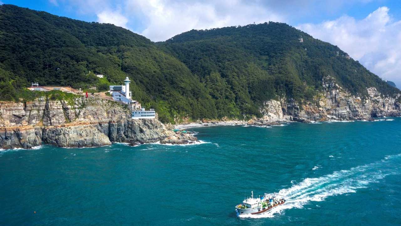 바다에서 바라본 태종대 해안 절벽과 영도등대. / 비짓부산