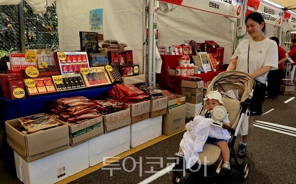 아이와 축제장 찾은 관광객이 홍삼판매부스를 구경하고 있다./사진=유경훈 기자