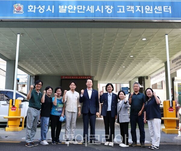 만세시장 고객지원센터 앞에서 상인들과 사진 찍는 정명근 시장/투어코리아뉴스 정명달 기자 사진=화성시