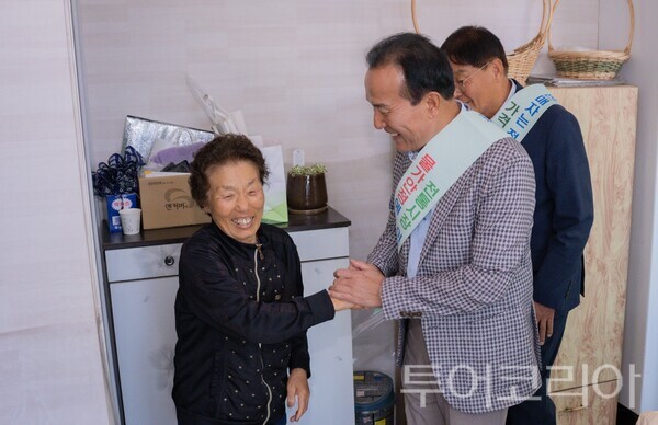 ▲지난 20일 전통시장 장보기 및 물가안정 캠페인에 나선 김홍열(오른쪽) 청양군수가 한 주민의 손을 맞잡으며 애로사항을 청취하고 있다. /사진-청양군