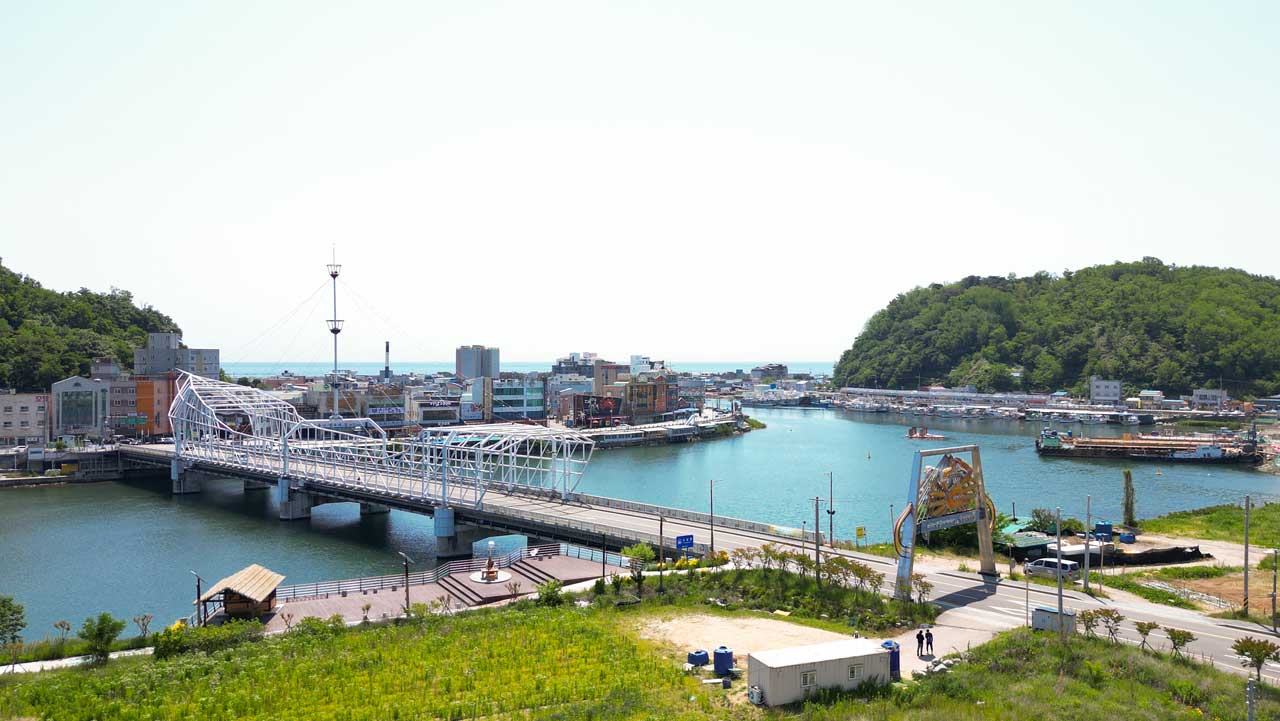 강구항 수로와 항구 주변 도로가 한눈에 내려다보이는 풍경. / 영덕스테이