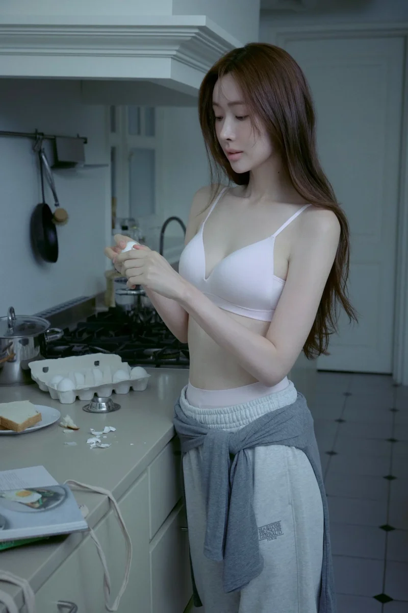 주방에서 계란을 든 채 화이트 브라렛 룩을 연출한 모습. / 사진=마리떼 프랑소와 저버