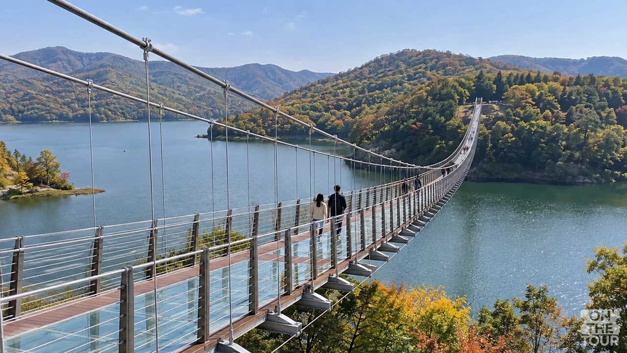 파주 마장호수 위를 가로지르는 출렁다리와 가을 산자락. (AI 생성) / 온더투어