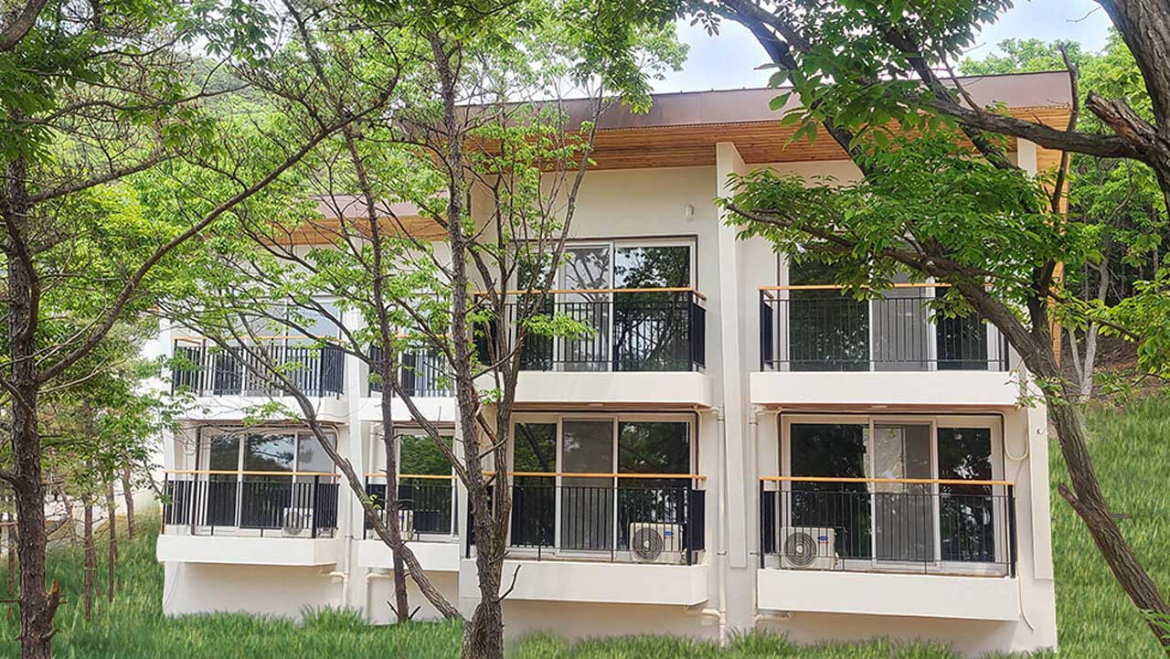 울창한 나무 사이에 자리한 국립무의도자연휴양림 연립동. / 숲나들e