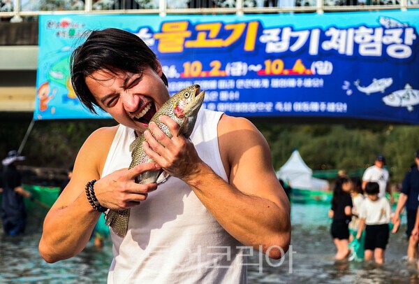 사진 / 완주와일드&로컬푸드 축제장에서 맨손 물고기 잡이를 하는 외국인 모습_완주군 제공