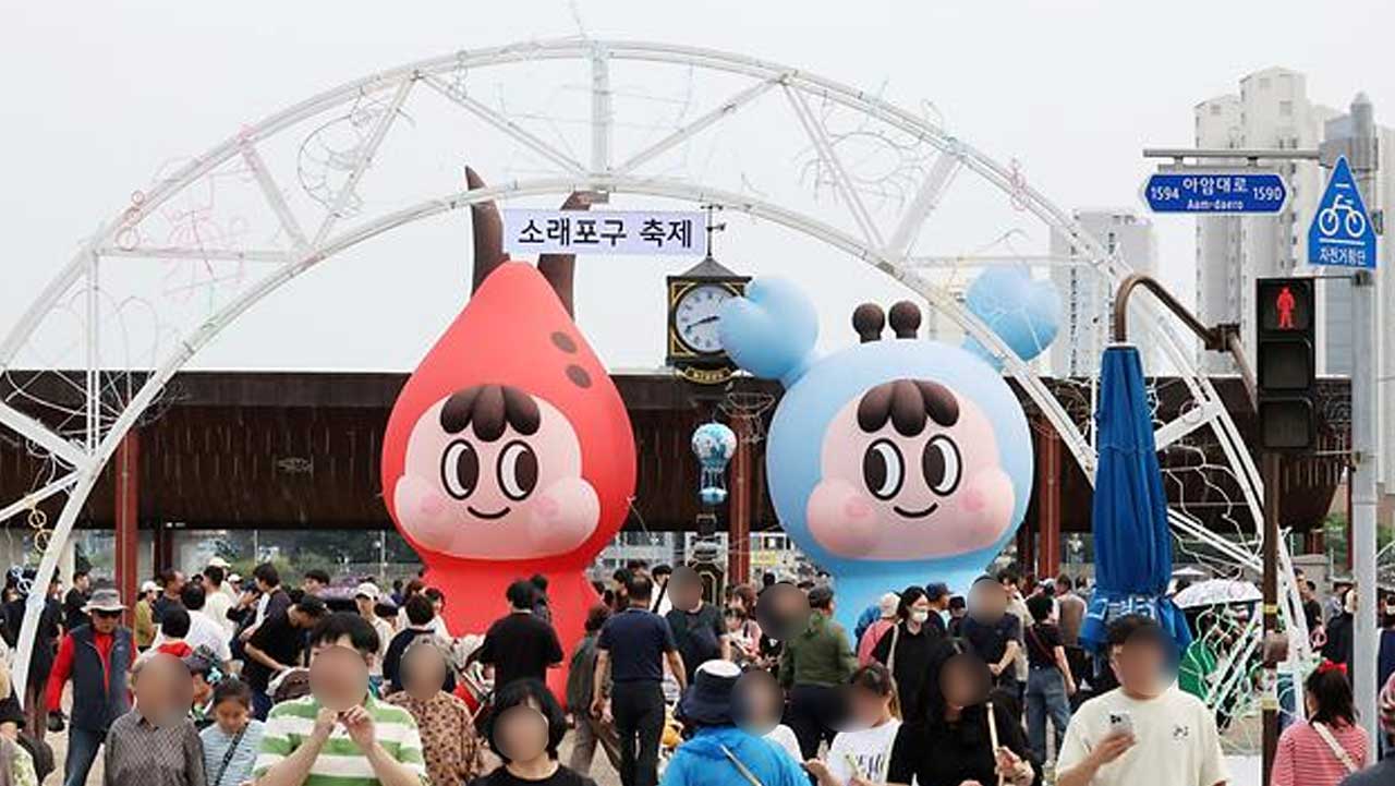 대형 캐릭터 조형물이 설치된 소래포구축제 입구를 지나가는 방문객들. / 남동구청