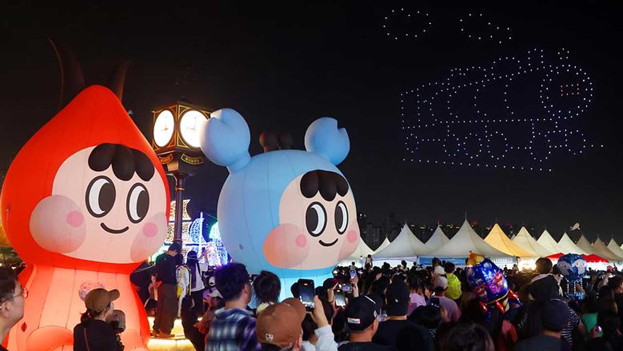소래포구축제 야간 행사에서 대형 캐릭터 조형물과 드론쇼를 바라보는 방문객들. / 남동구청